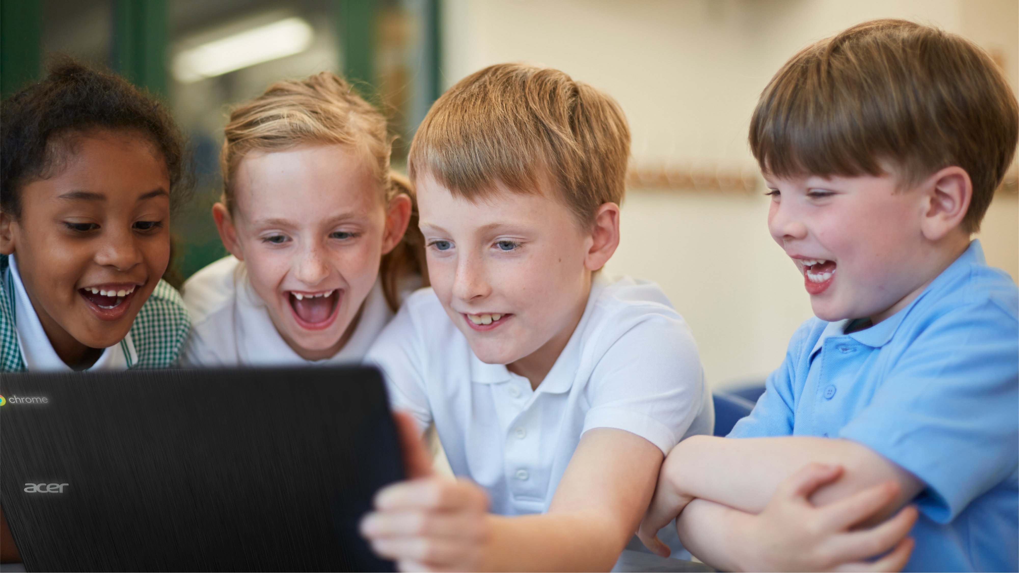 Kinder lachen während sie auf auf ein Google Chromebook schauen