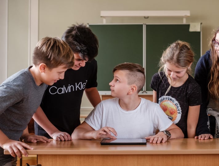 Ein Gruppe von Schüler:innen arbeitet kollaborativ mit dem iPad im Klassenzimmer