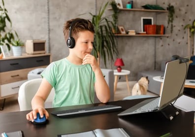 Schüler der mit einem Headset am Laptop arbeitet