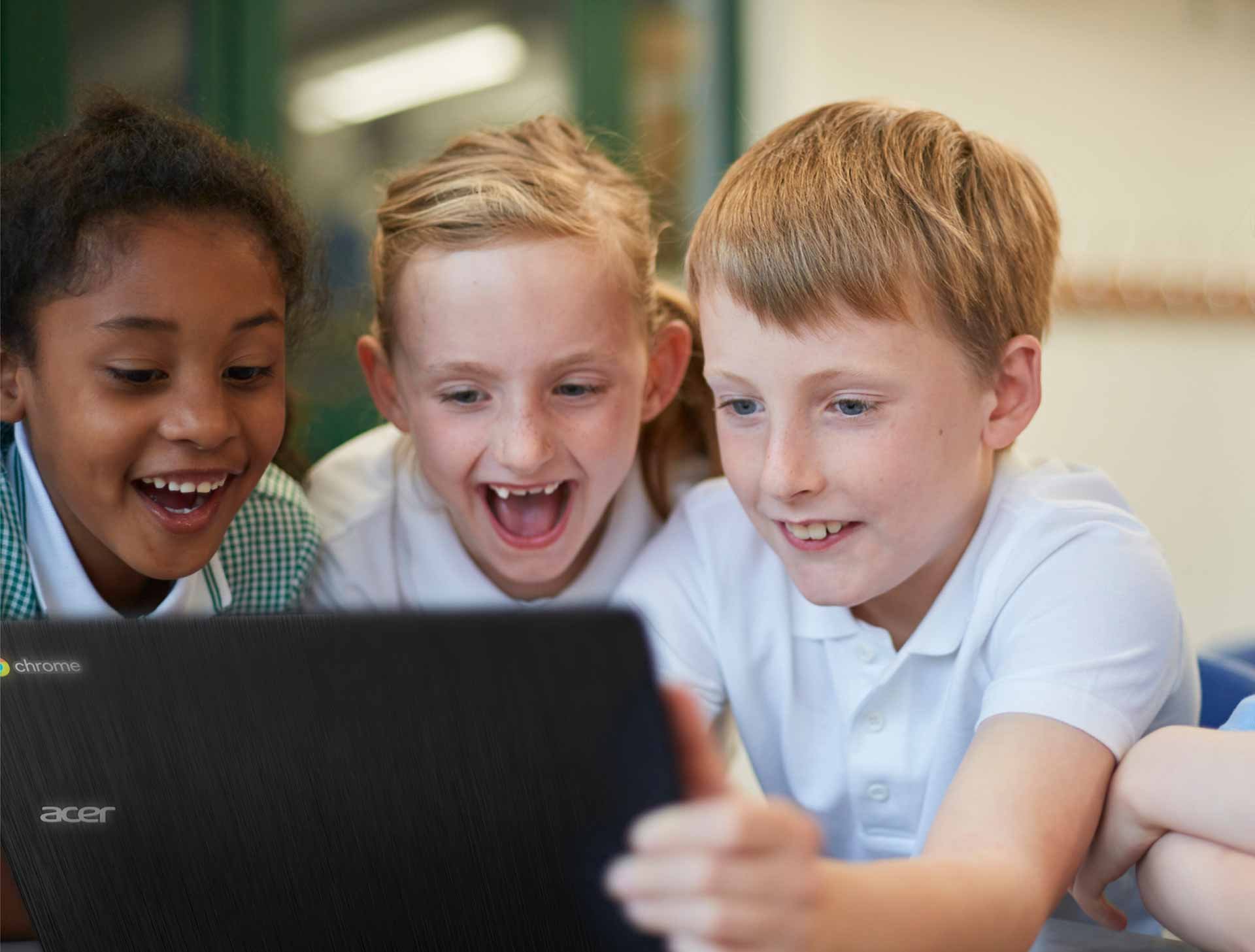 h_Lachchende Kinder halten ein edu-Chromebook im Klassenzimmer