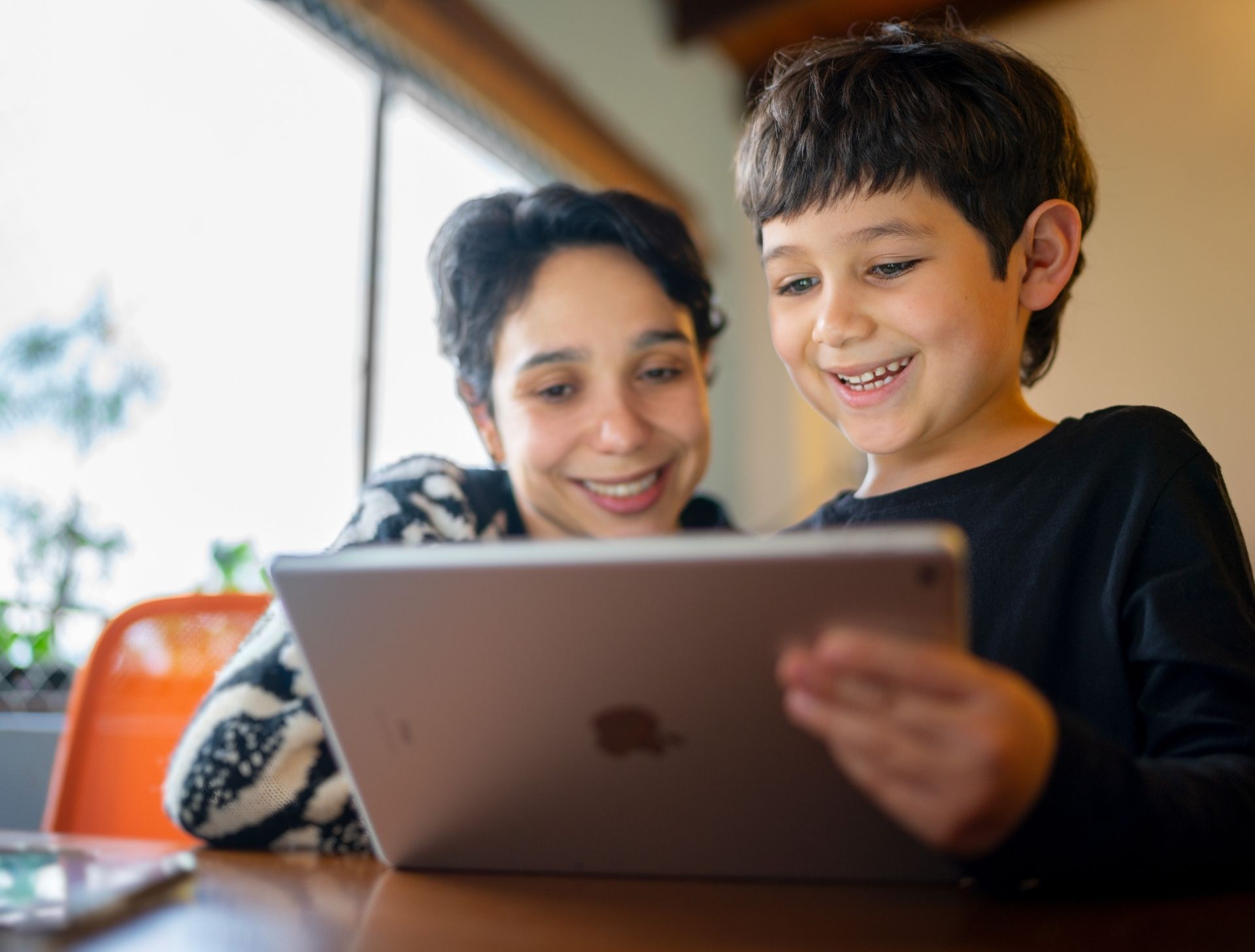 Zwei Schüler:innen bedienen ein iPad